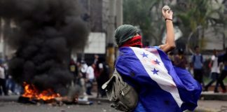 Imagen de archivo - Un jóven hondureño viste la bandera durante una manifestación en julio de 2019